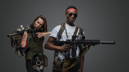 Photo for Studio shot of black macho man and woman survivors in post apocalyptic setting. - Royalty Free Image