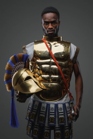 Photo for Studio shot of ancient greek warrior of african ethnic dressed in golden armor. - Royalty Free Image