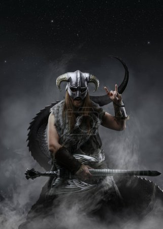 Téléchargez les photos : Art de l'ancien barbare viking jouant de la guitare contre le brouillard du ciel nocturne et la queue mystique. - en image libre de droit