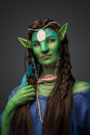 Foto de Retrato de mujer druida de cuento de hadas con piel verde vestida con joyas y vestido. - Imagen libre de derechos