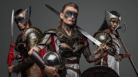 Photo for Studio shot of ancient amazons with cold steel dressed in armors against gray background. - Royalty Free Image