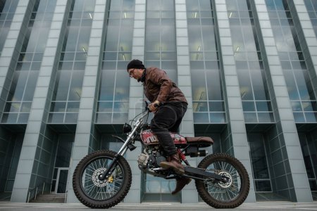 Téléchargez les photos : Portrait de gars branché chevauchant son vélo à l'ancienne dans le centre-ville. - en image libre de droit