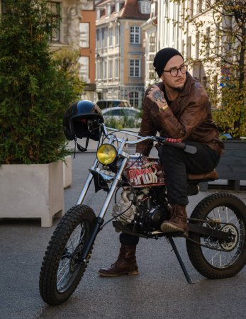 Photo for Shot of stylish guy dressed in leather jacket with custom bike outdoors. - Royalty Free Image