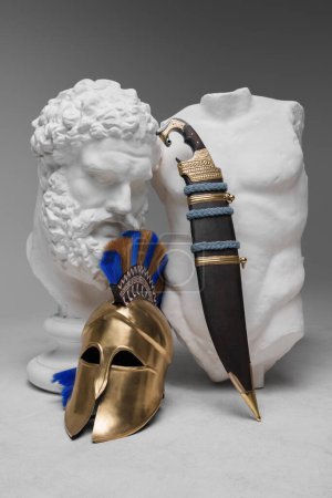 Photo for Shot of isolated on gray sculpture with weapons of soldier from ancient greece. - Royalty Free Image