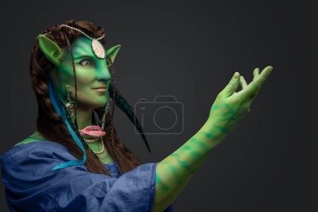 Foto de Estudio de druida elfo mágico con piel verde y joyas sobre fondo gris. - Imagen libre de derechos