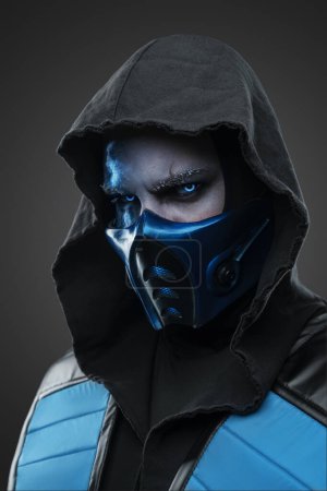 Photo for Portrait of Ice ninja with scar dressed in costume with hood staring at camera. - Royalty Free Image