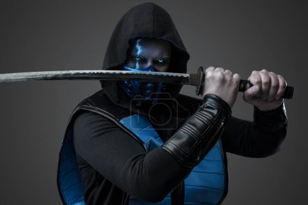 Photo for Portrait of Ice assassin dressed in costume with hood posing with katana. - Royalty Free Image
