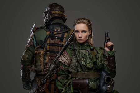Foto de Foto de aislado en gris dos soldados femeninos y masculinos posando espalda con espalda. - Imagen libre de derechos