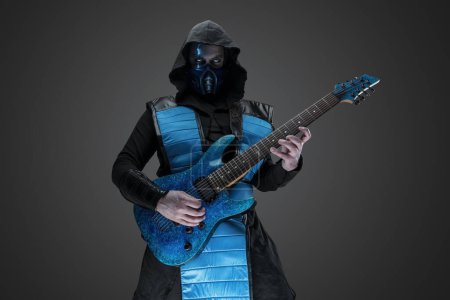 Photo for Shot of stealth assassin with guitar and hood staring at camera. - Royalty Free Image