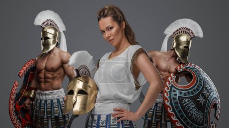 Téléchargez les photos : Guerrier grec antique femme et militaires vêtus de tuniques et casques à plumes. - en image libre de droit