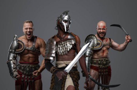 Téléchargez les photos : Prise de vue de gladiateurs multiculturels de l'ancien rôme sur fond gris. - en image libre de droit