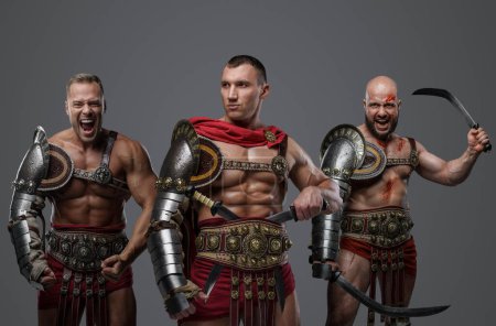 Foto de Disparo de gladiadores romanos vestidos con armadura ligera gritando a la cámara. - Imagen libre de derechos