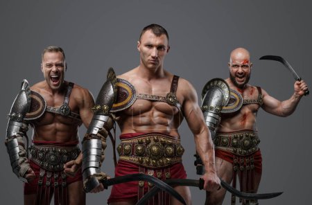 Foto de Disparo de gladiadores romanos vestidos con armadura ligera gritando a la cámara. - Imagen libre de derechos
