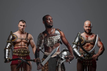 Foto de Foto de gladiadores antiguos multiétnicos vestidos con armadura posando juntos. - Imagen libre de derechos