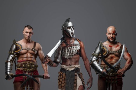 Foto de Tiro de gladiadores multiculturales de la antigua Roma sobre fondo gris. - Imagen libre de derechos