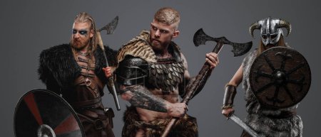 Téléchargez les photos : Studio plan de Isolé sur fond gris trois vikings barbares avec haches. - en image libre de droit