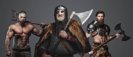 Foto de Estudio de tiro de anciano vikingo con dos bárbaros sobre fondo gris. - Imagen libre de derechos