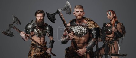 Foto de Tiro de vikingo muscular con bárbaros femeninos y masculinos con armas. - Imagen libre de derechos