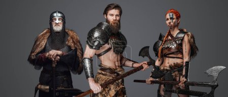 Téléchargez les photos : Photo studio de guerriers nordiques avec armure et haches regardant ensemble la caméra. - en image libre de droit