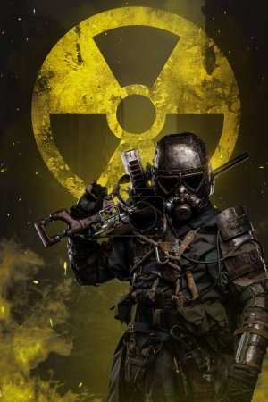 Photo for Post-apocalyptic soldier stands against yellow nuclear protection sign, holding a conceptual rifle and wearing unique anti-nuclear armor designed to protect against the dangers of a nuclear wasteland - Royalty Free Image
