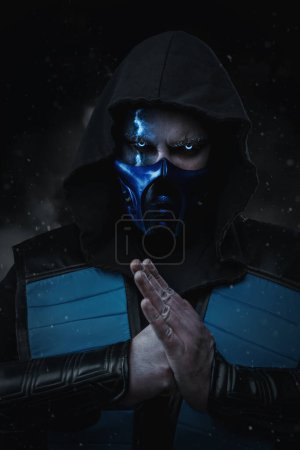 Photo for Shot of Ice assassin dressed in hood with fist and palm looking at camera. - Royalty Free Image