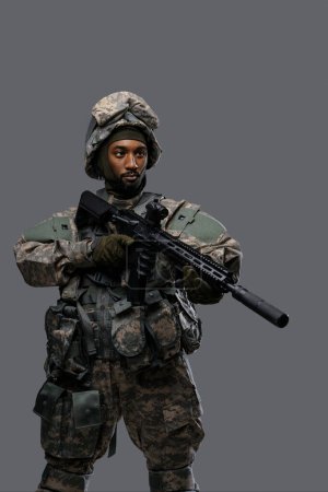 Foto de Soldado valiente en uniforme y casco de la OTAN con su rifle, enfocado en el objetivo, mostrando la valentía - Imagen libre de derechos