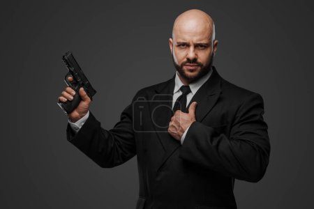 Foto de Protector determinado vestido formalmente con pistola, capturando su presencia al mando - Imagen libre de derechos