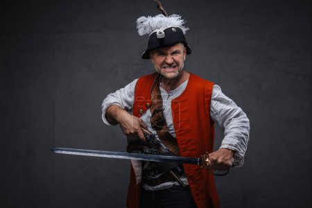 Photo for A menacing pirate with a gray beard dressed in white attire and a red vest, holding a musket and sword, preparing for combat against a textured backdrop - Royalty Free Image