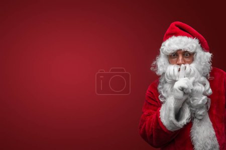 Téléchargez les photos : Père Noël geste silence avec le doigt sur les lèvres, mystérieux concept secret vacances - en image libre de droit