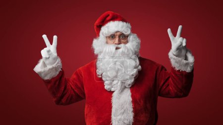 Foto de Santa Claus con signos de paz, difundiendo alegría y amor en Navidad - Imagen libre de derechos
