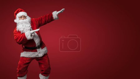 Photo for Santa Claus dancing, getting into the festive Christmas spirit - Royalty Free Image