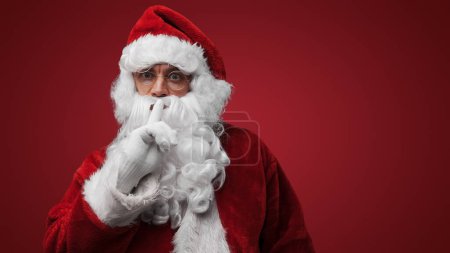 Foto de Santa Claus gesto de silencio con el dedo en los labios, misterioso concepto secreto de vacaciones - Imagen libre de derechos