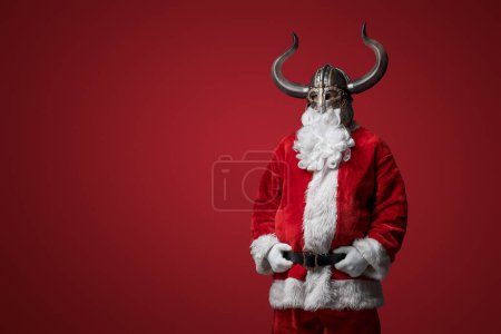 Foto de Santa Claus en traje vikingo, mezclando humorísticamente la alegría navideña con el antiguo espíritu guerrero - Imagen libre de derechos