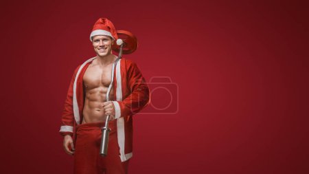Photo for Smiling Santa with a barbell, fitness during the holidays theme - Royalty Free Image