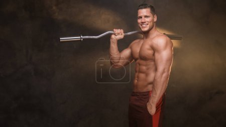 Foto de Hombre musculoso sonriente con un rizo bar en un ambiente de gimnasio de mal humor - Imagen libre de derechos
