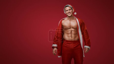 Foto de Alegre fitness Santa sonriendo con una chaqueta sobre su hombro - Imagen libre de derechos