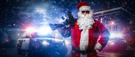 Un hombre vestido de Santa Claus, sosteniendo una ametralladora, posa frente a coches de policía con numerosas luces y sirenas policiales, en medio de una noche nevada y tormentosa en la calle