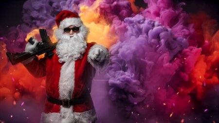Téléchargez les photos : Un homme habillé du Père Noël, armé d'une mitrailleuse, pointe son doigt dans une direction, posant au milieu d'une fumée vibrante et multicolore avec des étincelles colorées dans l'air - en image libre de droit
