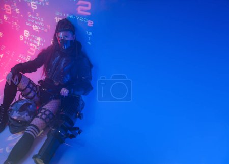 Foto de Una mujer con un traje negro táctico futurista yace en el suelo, con un casco de motocicleta y un proyector masivo junto a ella, en un contexto de símbolos digitales proyectados - Imagen libre de derechos