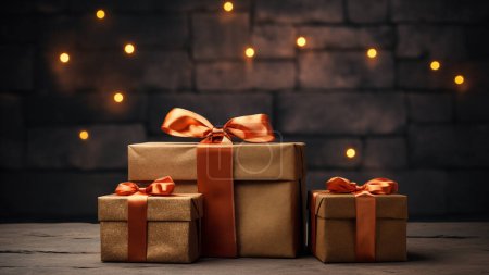 Téléchargez les photos : Boîtes cadeaux festives avec emballage doré et rubans élégants contre un mur de briques bokeh chaud. - en image libre de droit