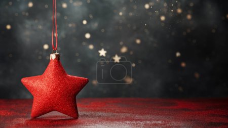 Foto de Un adorno rojo estrella de Navidad cuelga de un oscuro telón de fondo lleno de estrellas con bokeh festivo - Imagen libre de derechos