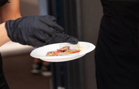 Téléchargez les photos : Gros plan des mains d'un restaurateur préparant de délicieux plats de palourdes crues et lisses - en image libre de droit