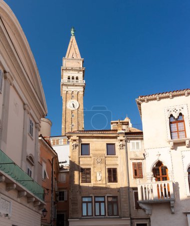 Photo for Historic buildings in Tartini Square in the medieval centre of Piran on the coast of Slovenia. The belltower of St George's Parish Church is in the background - Royalty Free Image