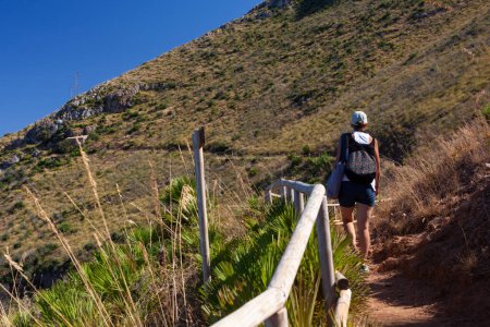 Téléchargez les photos : Touriste sur un sentier dans la réserve naturelle de Zingaro près de Scopello. Golfe de Castellammare sur l'île de Sicile - en image libre de droit
