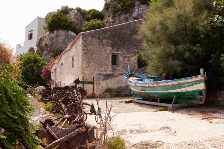 Foto de Antiguo barco en el patio de la antigua Tonnara di Scopello con las anclas de hierro una vez utilizado para la colocación de la trampa de atún, Sicilia - Imagen libre de derechos