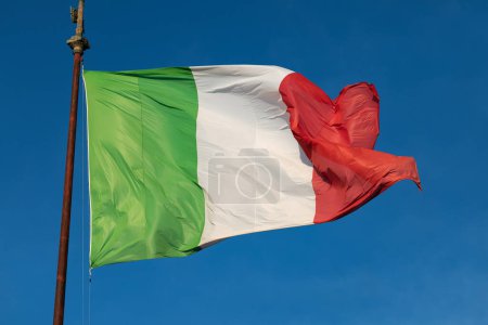 Téléchargez les photos : Drapeau italien agitant sur un ciel bleu - en image libre de droit