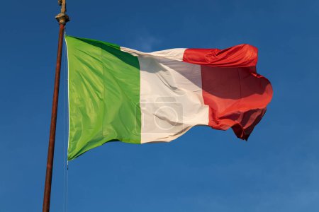 Téléchargez les photos : Drapeau italien agitant sur un ciel bleu - en image libre de droit
