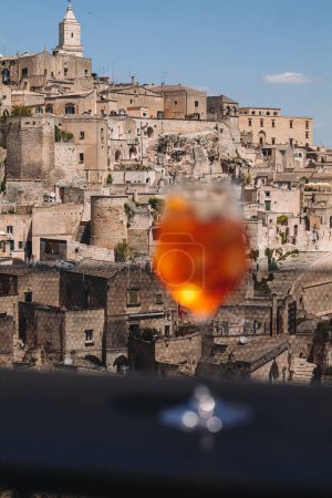 Photo for MATERA / ITALY - MAY 2023: Enjoying an Aperl Spritz with a wonderful view over the ancient town. - Royalty Free Image