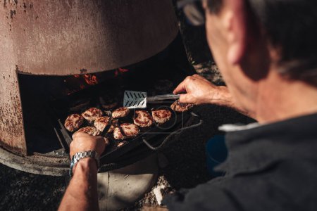 Téléchargez les photos : Cuisiner des hamburgers sur un barbecue - en image libre de droit