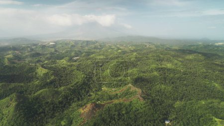 Bosque lluvioso verde brumoso monta vista aérea en Legazpi, Filipinas, Asia. Fuertes nubes de lluvia en el cielo sobre las montañas filipinas. Alta vegetación asiática árboles y hierba en tiro de dron de luz suave